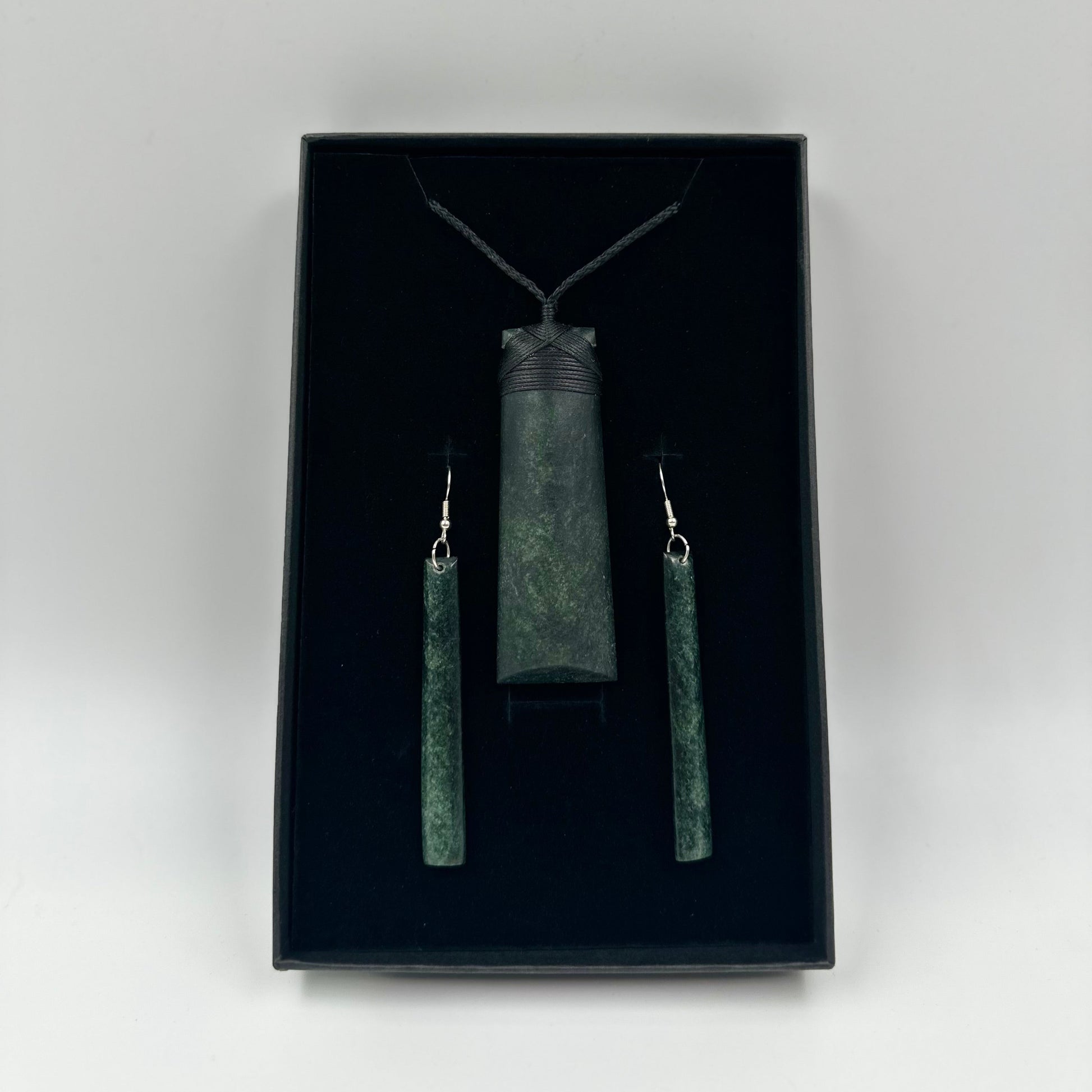 Jewelry set with pendant and earrings in a black box on a white 
background